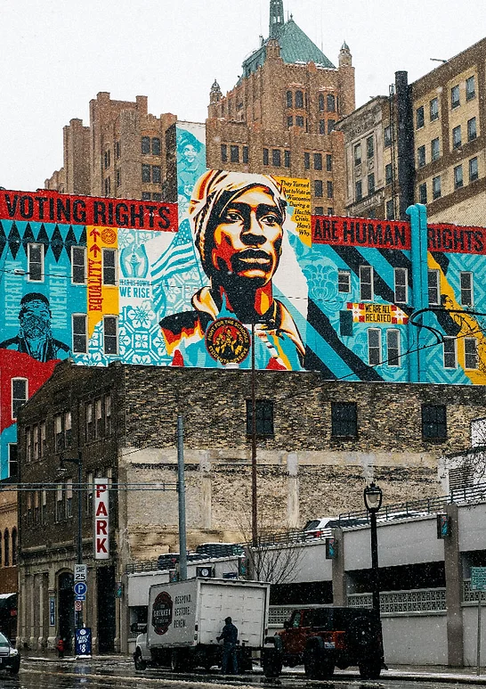 Sunlit rays fall across layered mountain ridges beneath dense cloud.